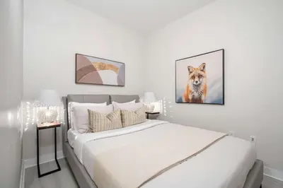a bedroom with a bed with a painting of a dog at Modern CityPlace 2BR Balcony & Free Parking in Toronto