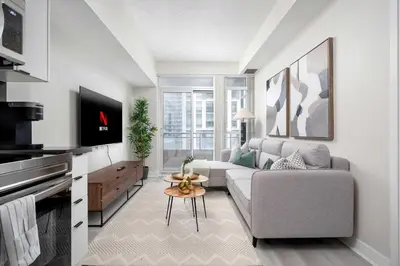 a living room with a couch and a tv at Modern CityPlace 2BR Balcony & Free Parking in Toronto