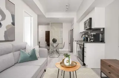 a living room with a couch and a table at Modern CityPlace 2BR Balcony & Free Parking in Toronto