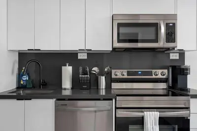 a kitchen with a stainless steel stove and microwave at Modern CityPlace 2BR Balcony & Free Parking in Toronto