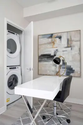 a white desk in a room with a washing machine at Modern CityPlace 2BR Balcony & Free Parking in Toronto