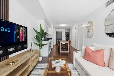 a living room with a white couch and a tv at Modern Downtown Retreat Cozy Living & City Views in Toronto