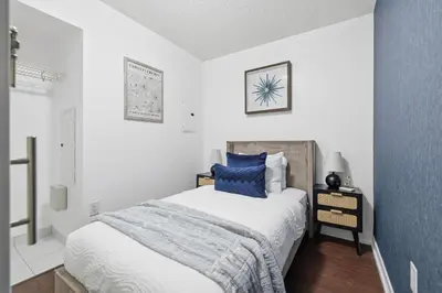 a bedroom with a bed with a blue pillow at Modern Downtown Retreat Cozy Living & City Views in Toronto
