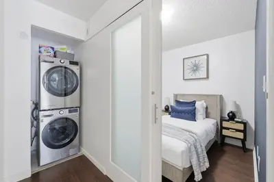 a bedroom with a washing machine and a washer and dryer at Modern Downtown Retreat Cozy Living & City Views in Toronto