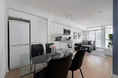 a kitchen and living room with a table and chairs at Modern CityPlace Sky Home 2BR 2BA & Balcony in Toronto