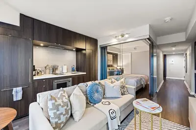 a living room with a couch and a bedroom at Sleek Yorkville King Suite Sleeps 5 DT in Toronto