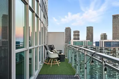 an apartment balcony with a desk and a view of the city at Luxury Parklawn Penthouse Breathtaking Lake View in Toronto
