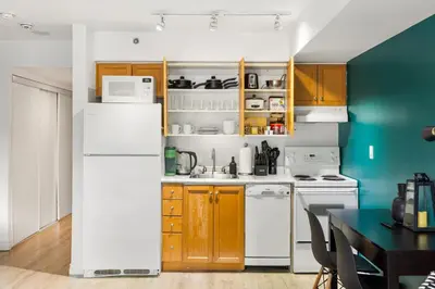 a kitchen with wooden cabinets and a white refrigerator at Downtown Oasis Sleek Suite by Yonge Dundas Sq in Toronto