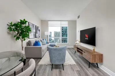 a living room with a couch and a tv at Bright 1BR Suite with Patio & CN Tower Views in Toronto