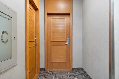 a wooden door in a hallway with a tile floor at Bright 1BR Suite with Patio & CN Tower Views in Toronto