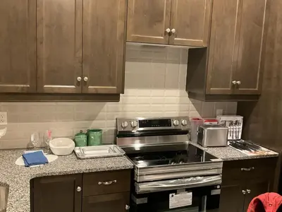 a kitchen with wooden cabinets and a stove top oven at 3bed Bright Oakville Townhome with balcony, office in Oakville