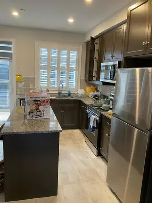 a kitchen with a stainless steel refrigerator and cabinets at 3bed Bright Oakville Townhome with balcony, office in Oakville