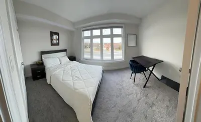 a bedroom with a bed and a desk and a window at 3bed Bright Oakville Townhome with balcony, office in Oakville