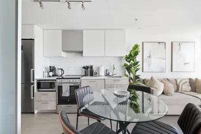 a kitchen and living room with a glass table at Stunning Family-Friendly Parking & City Views in Toronto
