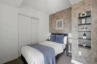 a bedroom with a large bed with blue pillows at Stunning Family-Friendly Parking & City Views in Toronto