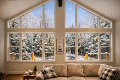 a large window in a living room with a couch at Waterfront Muskoka Cottage with FirePit, BBQ and Canoes in Bracebridge