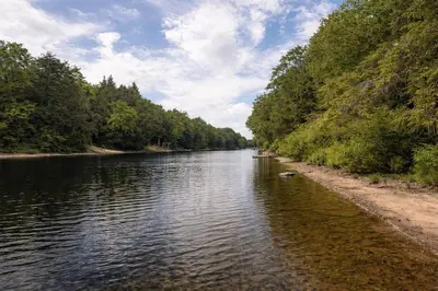 a river with trees on the side of it at Waterfront Muskoka Cottage with FirePit, BBQ and Canoes in Bracebridge