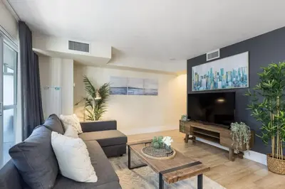 a living room with a couch and a tv at Modern 1BR Retreat with Balcony & Parking in Toronto