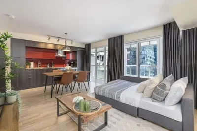 a living room with a bed and a dining room at Modern 1BR Retreat with Balcony & Parking in Toronto