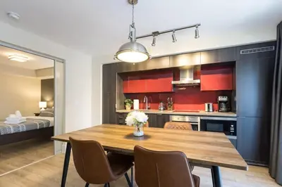 a kitchen and dining room with a wooden table and chairs at Modern 1BR Retreat with Balcony & Parking in Toronto