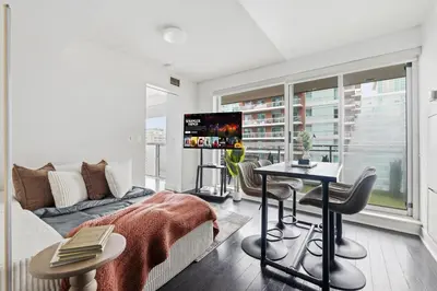 a living room with a couch and a tv at Modern 1BR in Liberty Village Walk Score 90 in Toronto
