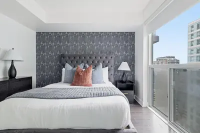 a bedroom with a large bed and a large window at Modern 1BR in Liberty Village Walk Score 90 in Toronto