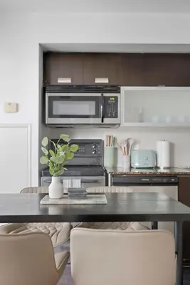 a kitchen with a table with chairs and a microwave at Modern 1BR in Liberty Village Walk Score 90 in Toronto