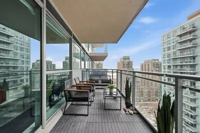 a balcony with chairs and tables on a building at Modern 1BR in Liberty Village Walk Score 90 in Toronto
