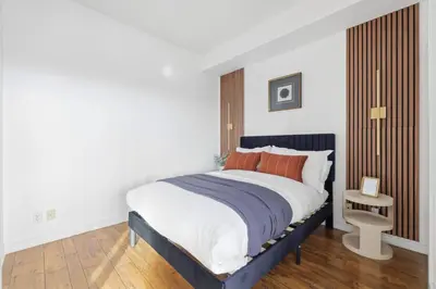a bedroom with a large bed with orange pillows at Chic Bay St Condo Skyline Views 55 TV in Toronto