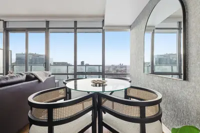 a living room with a table and chairs and windows at Chic Bay St Condo Skyline Views 55 TV in Toronto