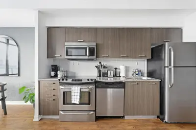 a kitchen with stainless steel appliances and a microwave at Chic Bay St Condo Skyline Views 55 TV in Toronto