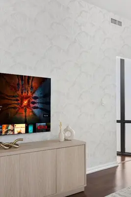 a living room with a flat screen tv on a wall at Designer Bay Street Condo Sleep 6 in Toronto