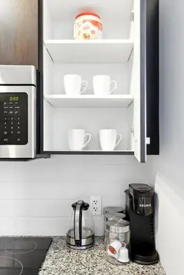 a kitchen counter with cups and a coffee maker at Financial District Oasis Sleeps 5 55 TV in Toronto