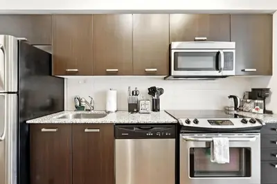 a kitchen with a stove and a microwave at Financial District Oasis Sleeps 5 55 TV in Toronto