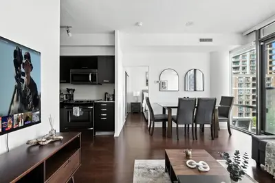 a kitchen and living room with a table and chairs at Financial District Oasis Sleeps 5 55 TV in Toronto
