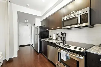 a kitchen with a stove and a microwave at Financial District Oasis Sleeps 5 55 TV in Toronto