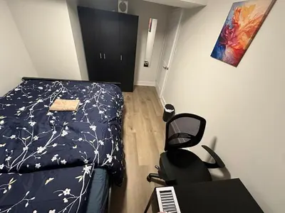 a bedroom with a bed and a desk and a chair at Cozy Parkside 2 Bedroom Basement Suite in Vaughan