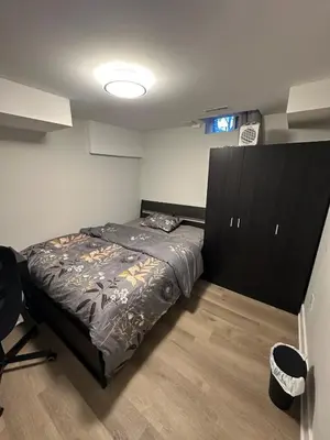 a bedroom with a bed with a black headboard at Cozy Parkside 2 Bedroom Basement Suite in Vaughan