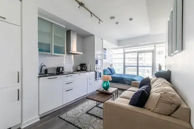 a living room with a couch and a kitchen at Modern Studio Condo High Floor Downtown Toronto in Toronto