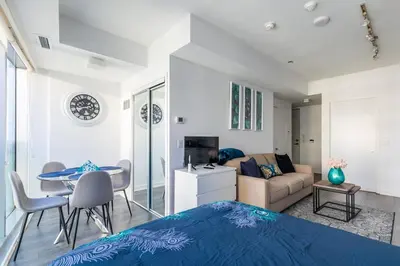 a bedroom with a bed and a living room at Modern Studio Condo High Floor Downtown Toronto in Toronto