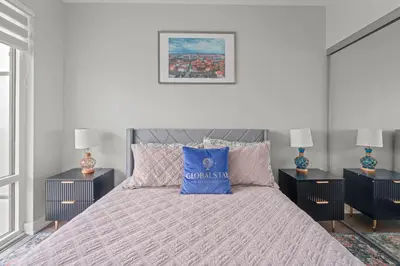 a bedroom with a bed with a blue pillow on it at New Cozy 1 Bedroom & Den Condo in Downtown Toronto in Toronto