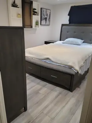 a bedroom with a bed with a wooden floor at Cozy 2 bedroom ice fishing&skiing in Georgina