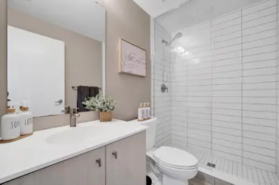 a white bathroom with a toilet and a sink at Propercare - The Wellingtons in Kitchener