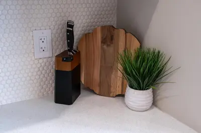 a plant in a vase next to a wooden cutting board at Propercare - The Wellingtons in Kitchener