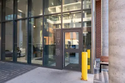 a glass building with a door and a yellow pole at Propercare - The Wellingtons in Kitchener
