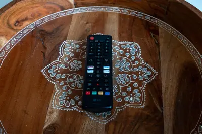 a remote control sitting on top of a wooden table at Propercare - The Wellingtons in Kitchener