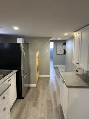 a kitchen with white cabinets and a black refrigerator at 1 Bedroom Basement with parking and Backyard in Hamilton