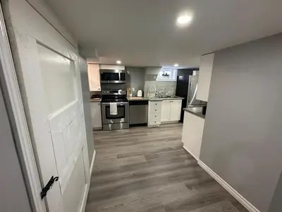 a kitchen with white cabinets and stainless steel appliances at 1 Bedroom Basement with parking and Backyard in Hamilton