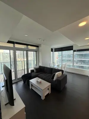 a living room with a couch and a tv at Luxury 2 Bedroom 2 Baths Condo Downtown Toronto in Toronto