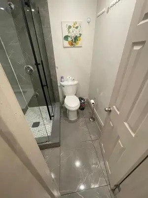 a bathroom with a toilet and a glass shower at FIFA CENTRAL TORONTO-DIRECT TO BMO FIELD-Live Game Atmosphere-Free Wifi in Toronto
